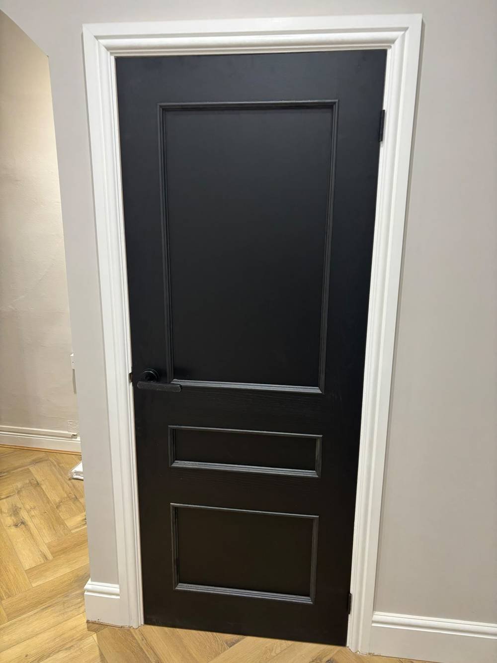 Black painted internal door with herringbone flooring