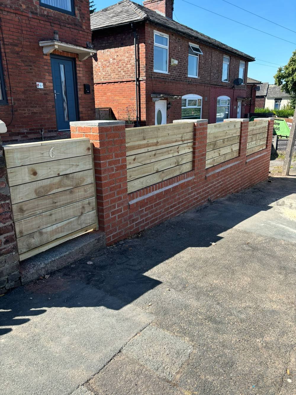 Brick garden wall with timber panel infill and gate