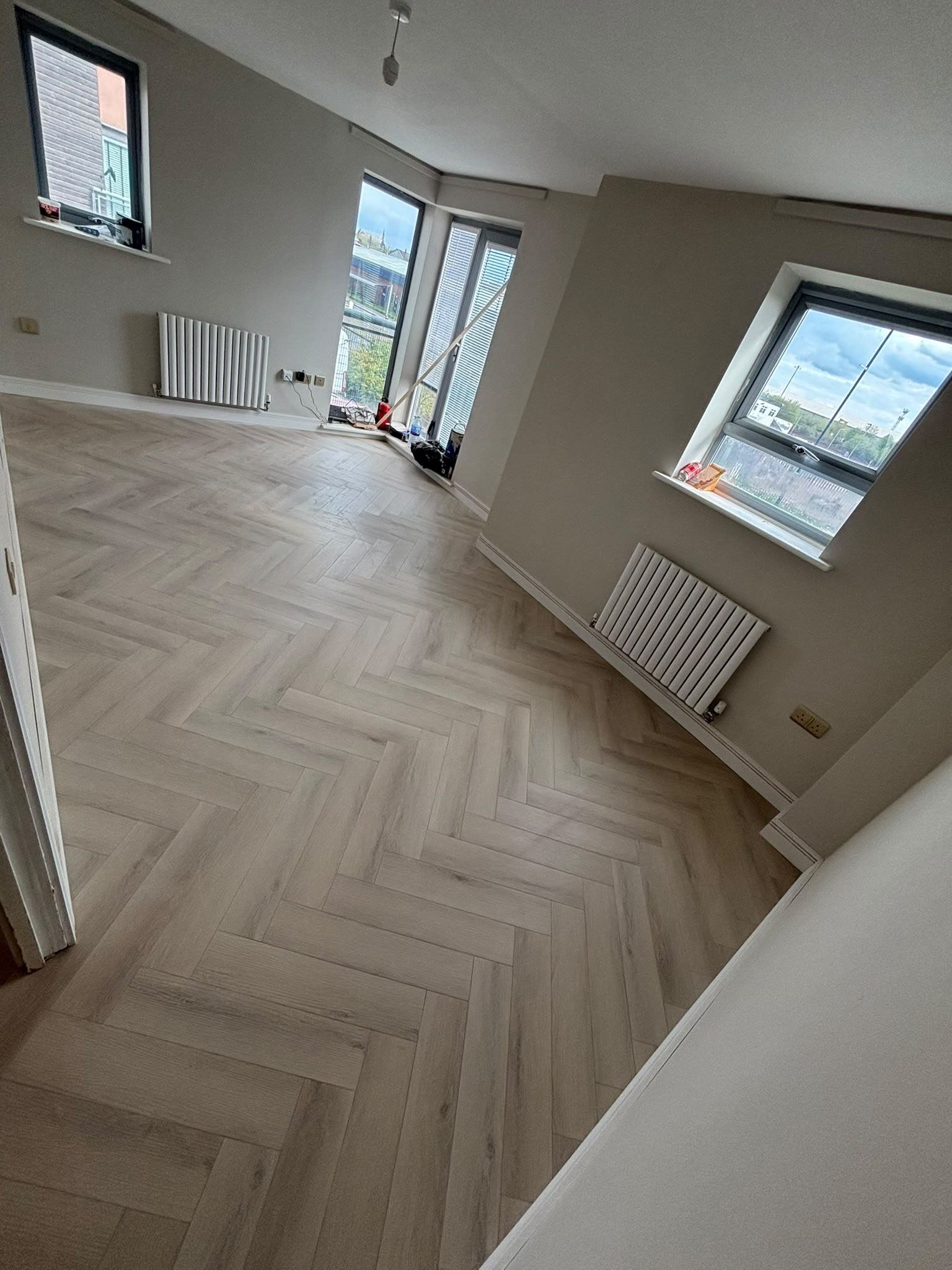Herringbone flooring fitted in an open-plan living space by LMF Joinery