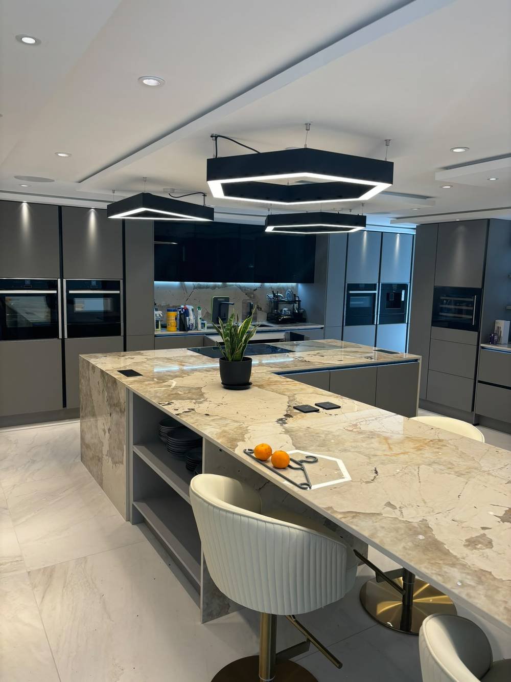 Kitchen island with book-matched marble and feature pendant lighting