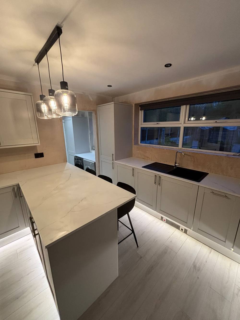 Kitchen island with marble worktop and pendant lighting
