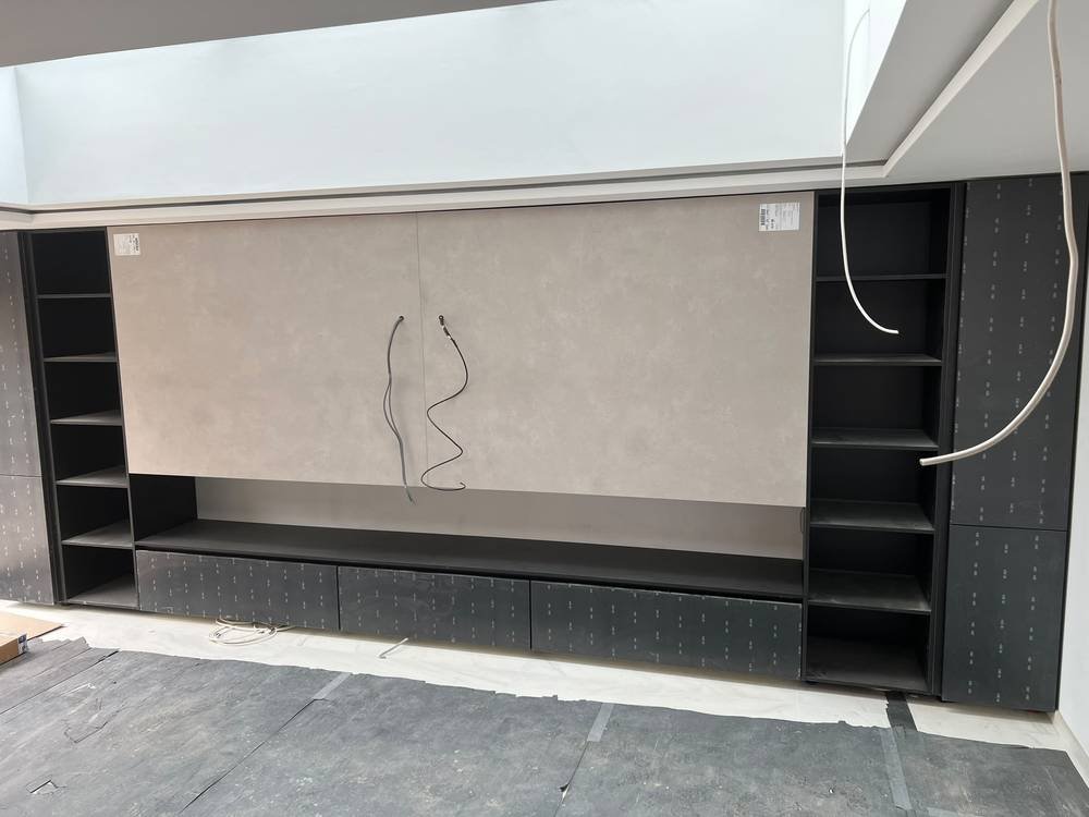 Media wall cabinetry under construction with shelving either side
