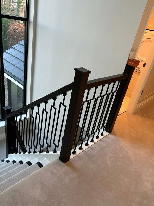 Modern staircase with black spindles by LMF Joinery