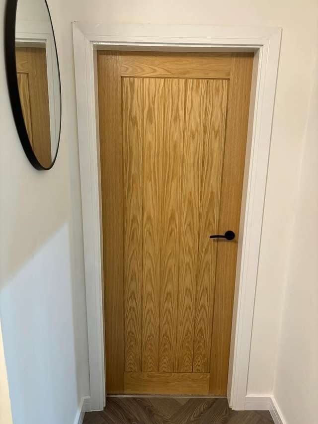 Oak internal door with black handle fitted by LMF Joinery