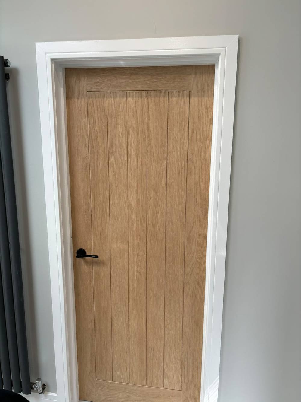 Oak panelled door with black handle