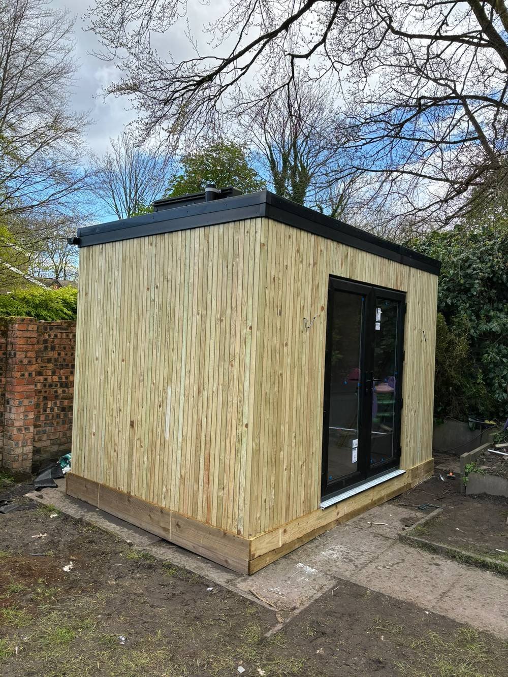 Timber-clad garden room with glazed double doors