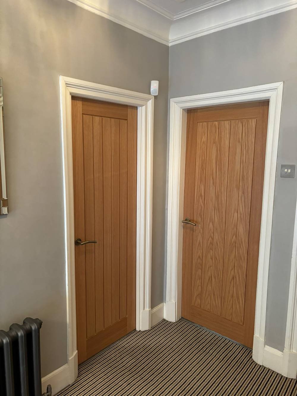 Two oak panelled doors fitted in a hallway