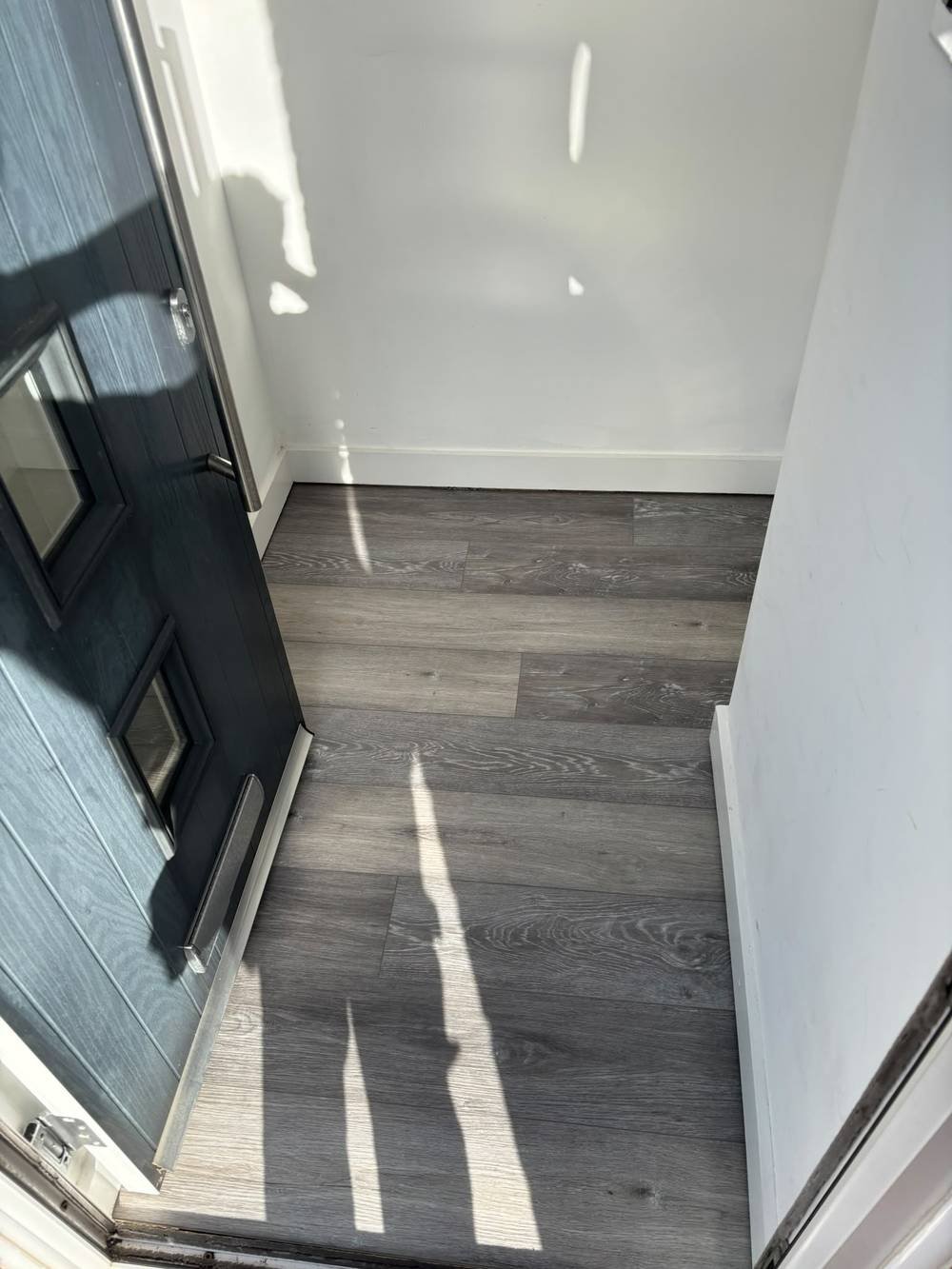 Wood-effect vinyl flooring fitted by a front entrance